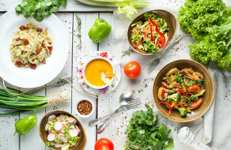 Vegetables and sauces in bowls on a table